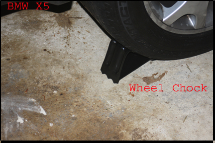 BMW X5 - Shows chocks under front tires before jacking up rear end of X5.