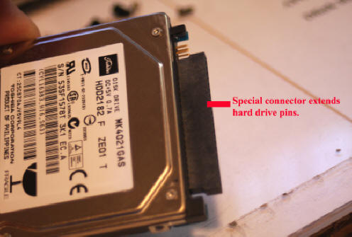 Laptop hard drive with pin extender attached.