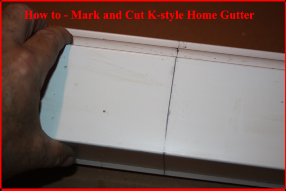 K-style home roof gutter marked for cutting.